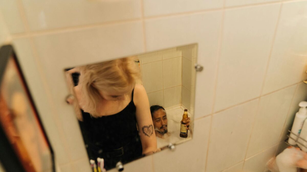 woman in black tank top standing in front of mirror