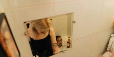 woman in black tank top standing in front of mirror