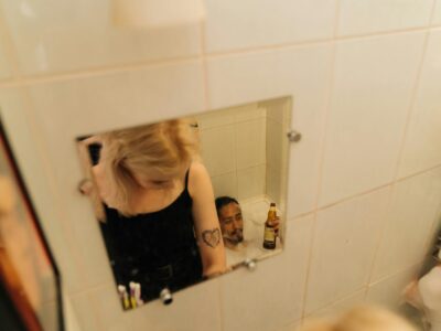 woman in black tank top standing in front of mirror