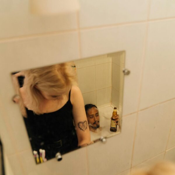woman in black tank top standing in front of mirror